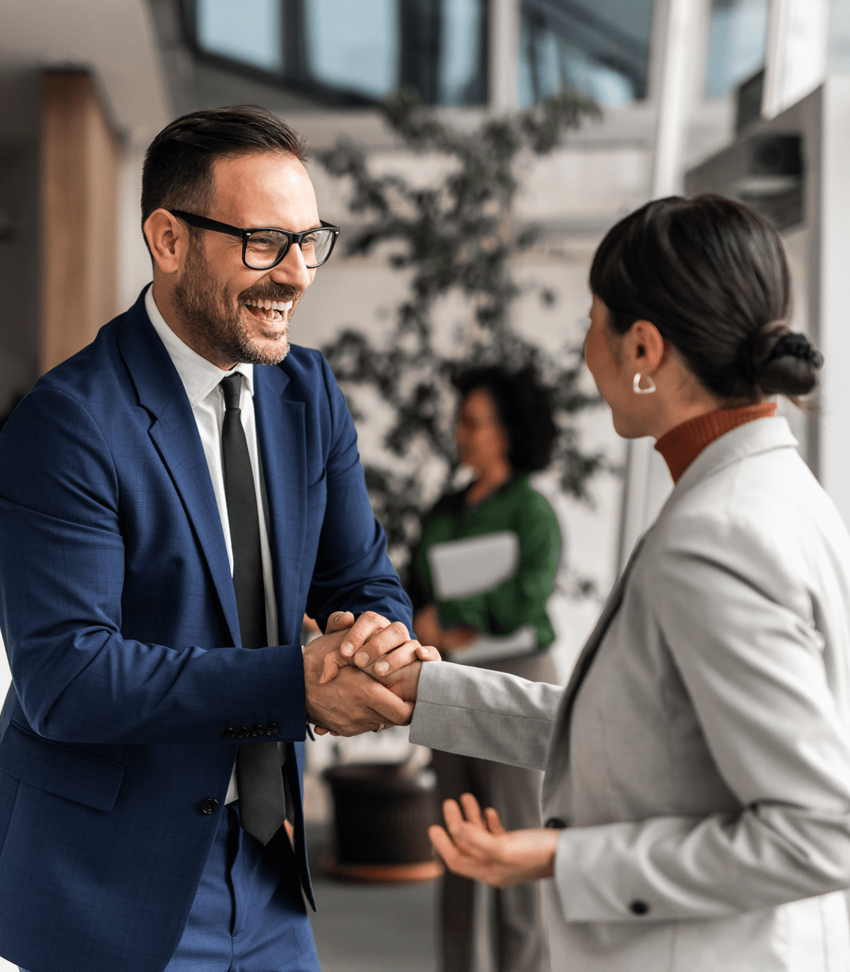 Man and woman shaking hands in office.