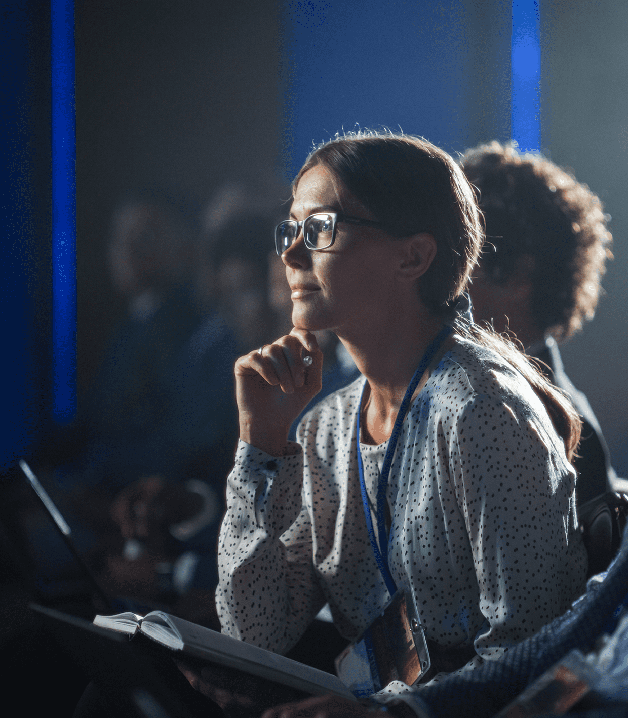 Woman attentively listening at a conference.